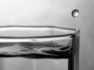 Drop of water falling on the edge of the glass