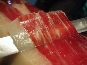Cutting a thin slice of Iberian ham