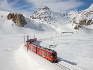 Train passing through a landscape of snowy mountains