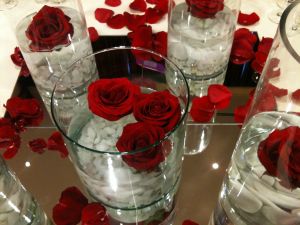 Glass vases with water and red roses