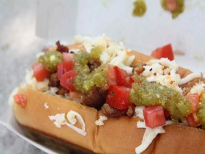 Hot dog with diced tomato, cheese and more