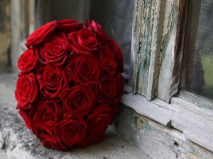 Red roses ball next to a wooden window