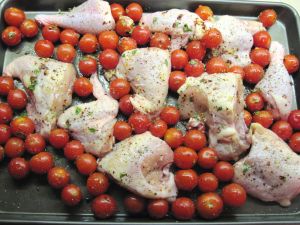 Tray with chicken and tomatoes before putting in the oven