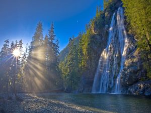 Sun rays illuminating a waterfall