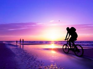 Crossing the beach at sunset on bicycle
