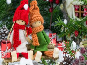 Little dolls next to Christmas tree