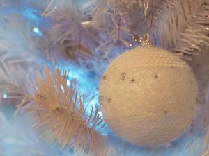 Delicate white ball hanging from Christmas tree