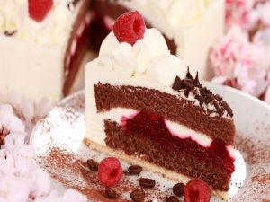 Cake with cream, raspberry, chocolate and coffee beans