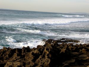 The ocean waves crashing on the rocks