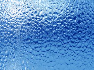 Water drops over blue glass